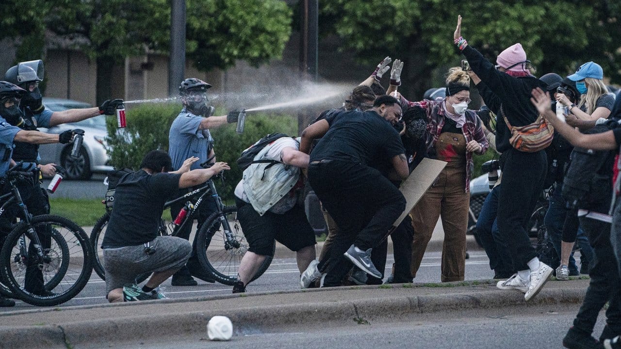 Polizisten sprühen aus kurzer Distanz Pfefferspray auf Demonstranten in Minneapolis.