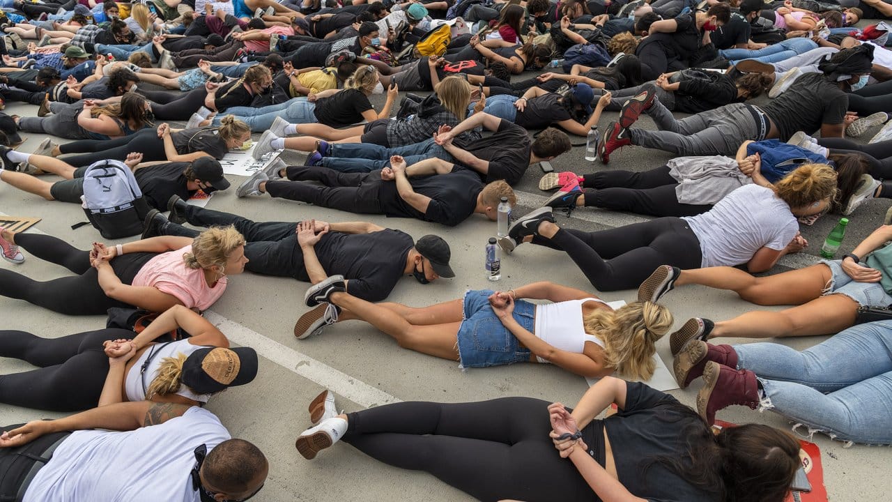 Demonstranten liegen in San Diego bei einem Protest mit hinter dem Rücken verschränkten Armen auf dem Boden.