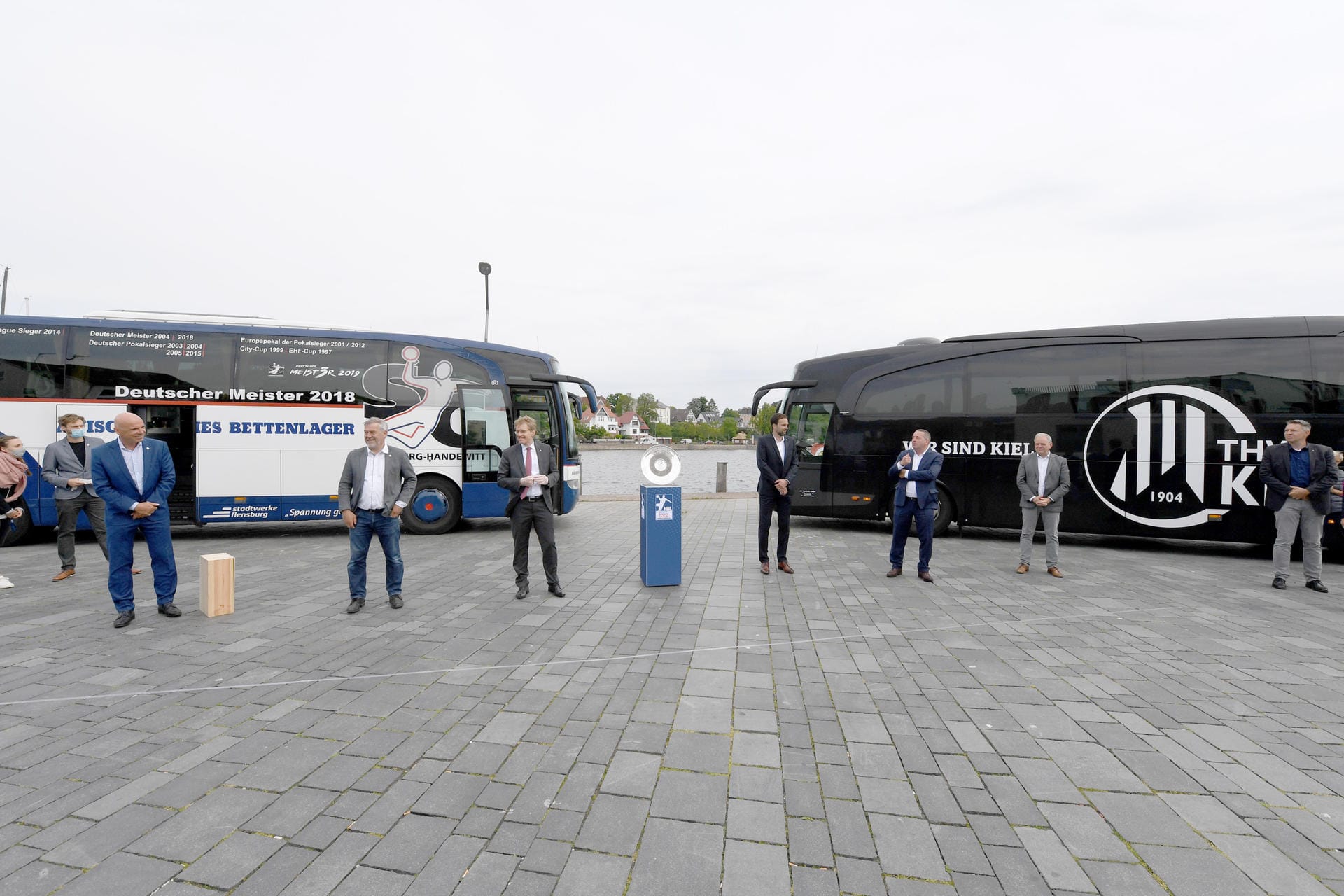 Zwischen den Mannschaftsbussen von SG Flensburg-Handewitt und THW Kiel steht die Meisterschale auf einem Sockel: Der THW Kiel war nach dem Saisonabbruch zum Meister erklärt worden.