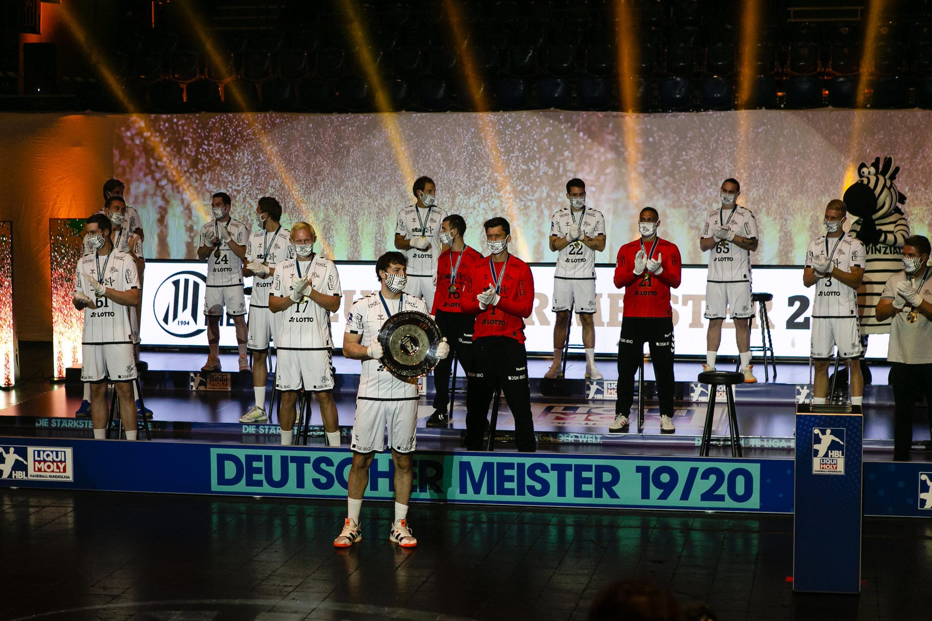Die Spieler des THW Kiel stehen auf einem Podest: Wegen der Einschränkungen im Zuge der Corona-Pandemie mutete die feierliche Ehrung des neuen Handballmeisters etwas bizarr an. "Das war einfach surreal, sich so dafür feiern zu lassen vor einer fast leeren Halle", sagte Nationalspieler Hendrik Pekeler. Die Spieler des THW Kiel stehen auf einem Podest: Wegen der Einschränkungen im Zuge der Corona-Pandemie mutete die feierliche Ehrung des neuen Handballmeisters etwas bizarr an. "Das war einfach surreal, sich so dafür feiern zu lassen vor einer fast leeren Halle", sagte Nationalspieler Hendrik Pekeler.