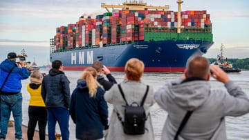 Menschen stehen mit Kameras am Elbufer: Das weltgrößte Containerschiff "HMM Algeciras" hat viele Schaulustige angezogen.
