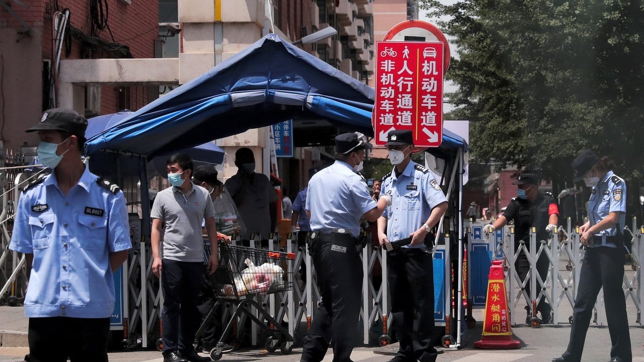 Polizisten und Sicherheitsbeamte vor abgeriegelten Wohngebäuden in der chinesischen Hauptstadt. Polizisten und Sicherheitsbeamte vor abgeriegelten Wohngebäuden in der chinesischen Hauptstadt.