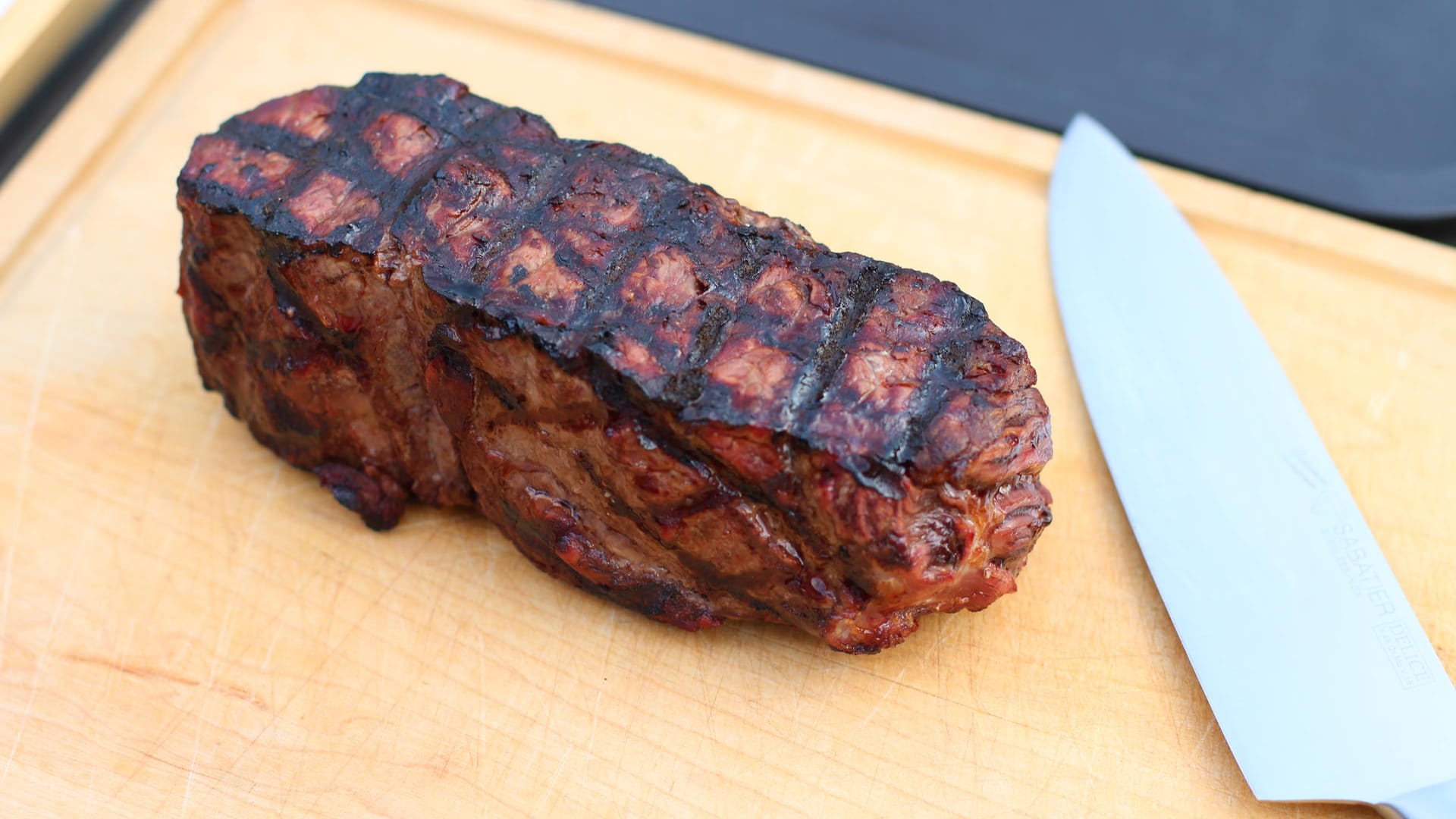 Lassen Sie das fertige Fleisch kurz ruhen und belegen Sie das Brötchen solange mit Soße, Salat und eingelegten Paprikascheiben.