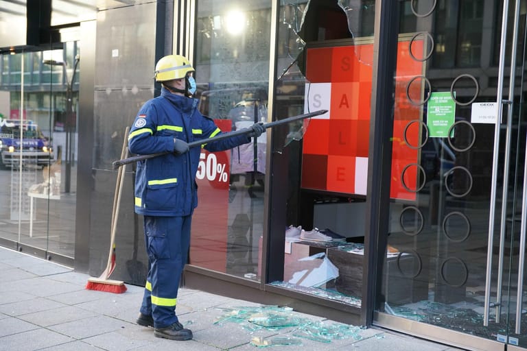 Ein Mitarbeiter vom THW beseitigt Fensterscherben in der Stuttgarter Innenstadt.