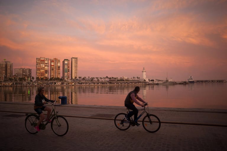 June 18, 2020, Malaga, Spain: Cyclist are seen riding at sunset along the walk Muelle Uno during eased restrictions..Mos