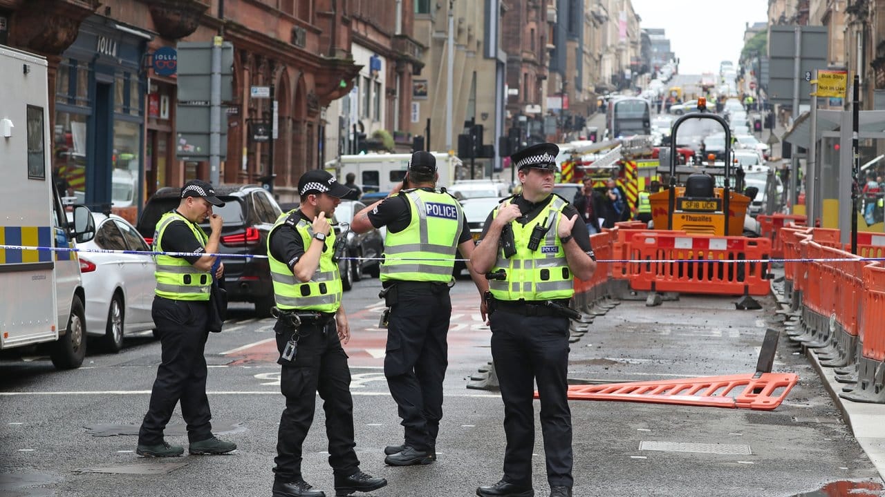 Polizisten stehen am abgesperrten Tatort in der West George Street in Glasgow.