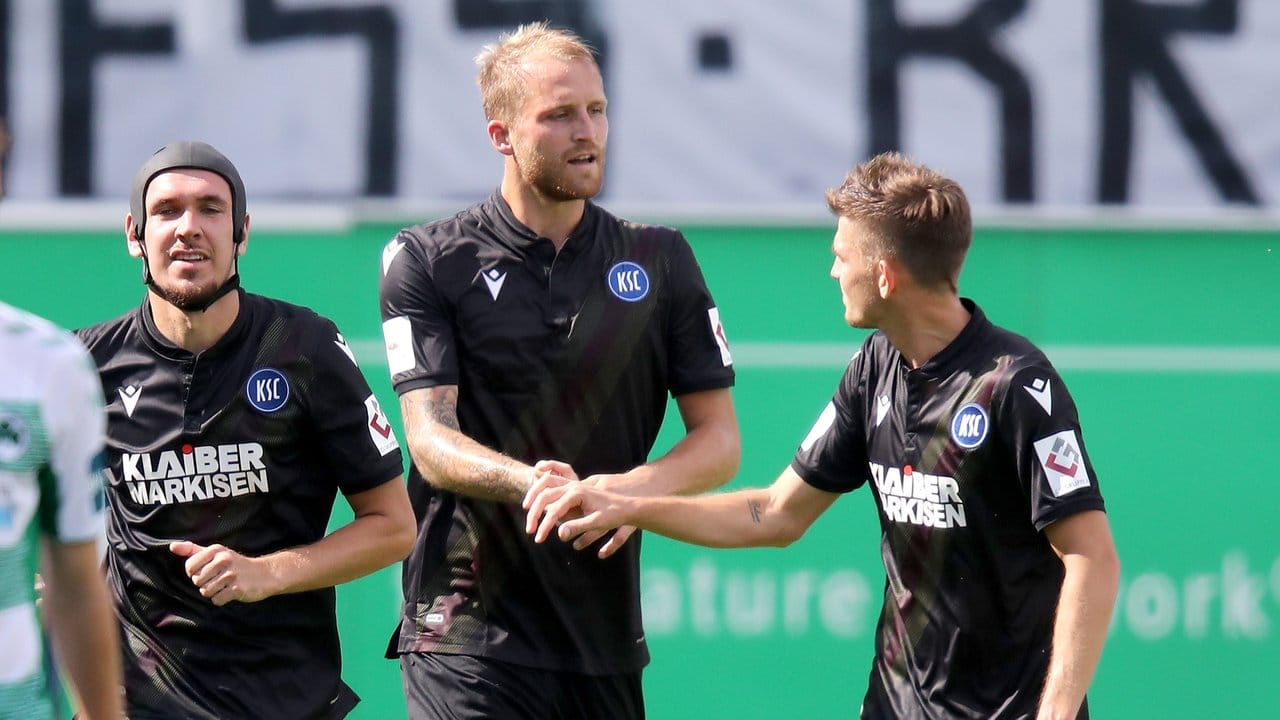 Karlsruhes Philipp Hofmann (M) jubelt mit seinen Kollegen Damian Roßbach (l) und Marvin Wanitzek über seinen Treffer durch Strafstoß zum 2:1.
