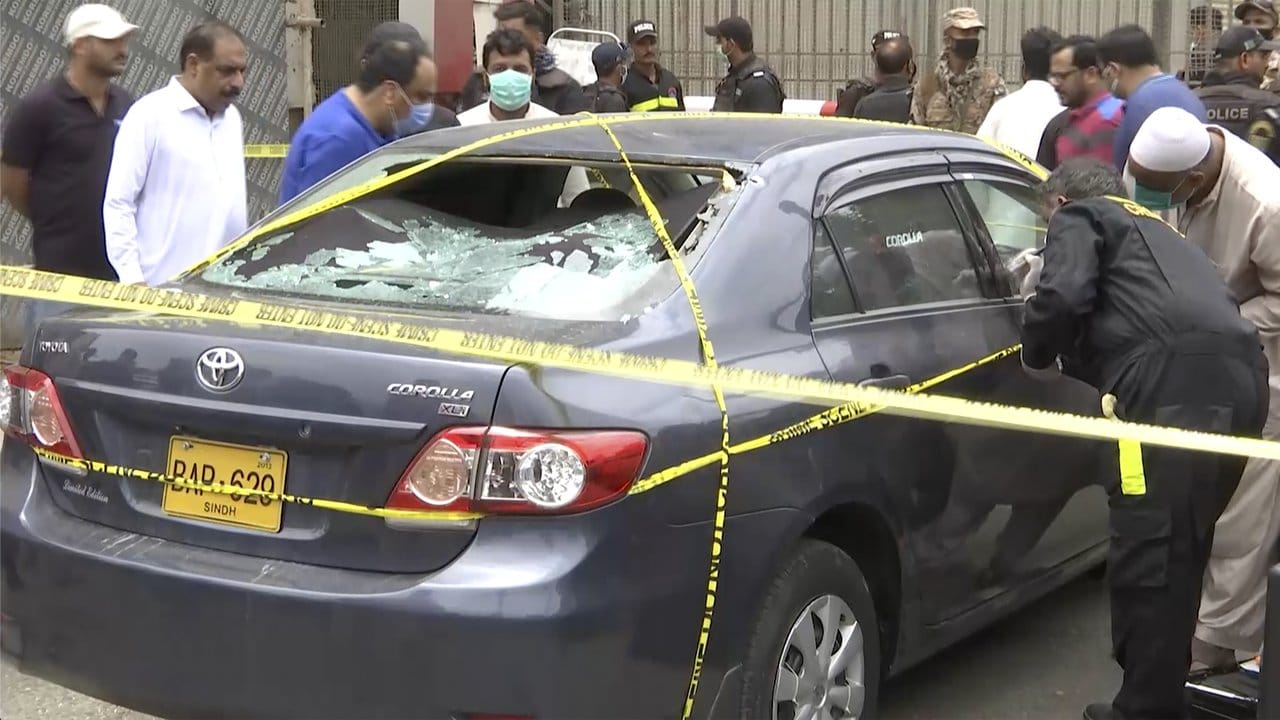 Polizisten untersuchen ein Auto, das von den Angreifern benutzt wurde.
