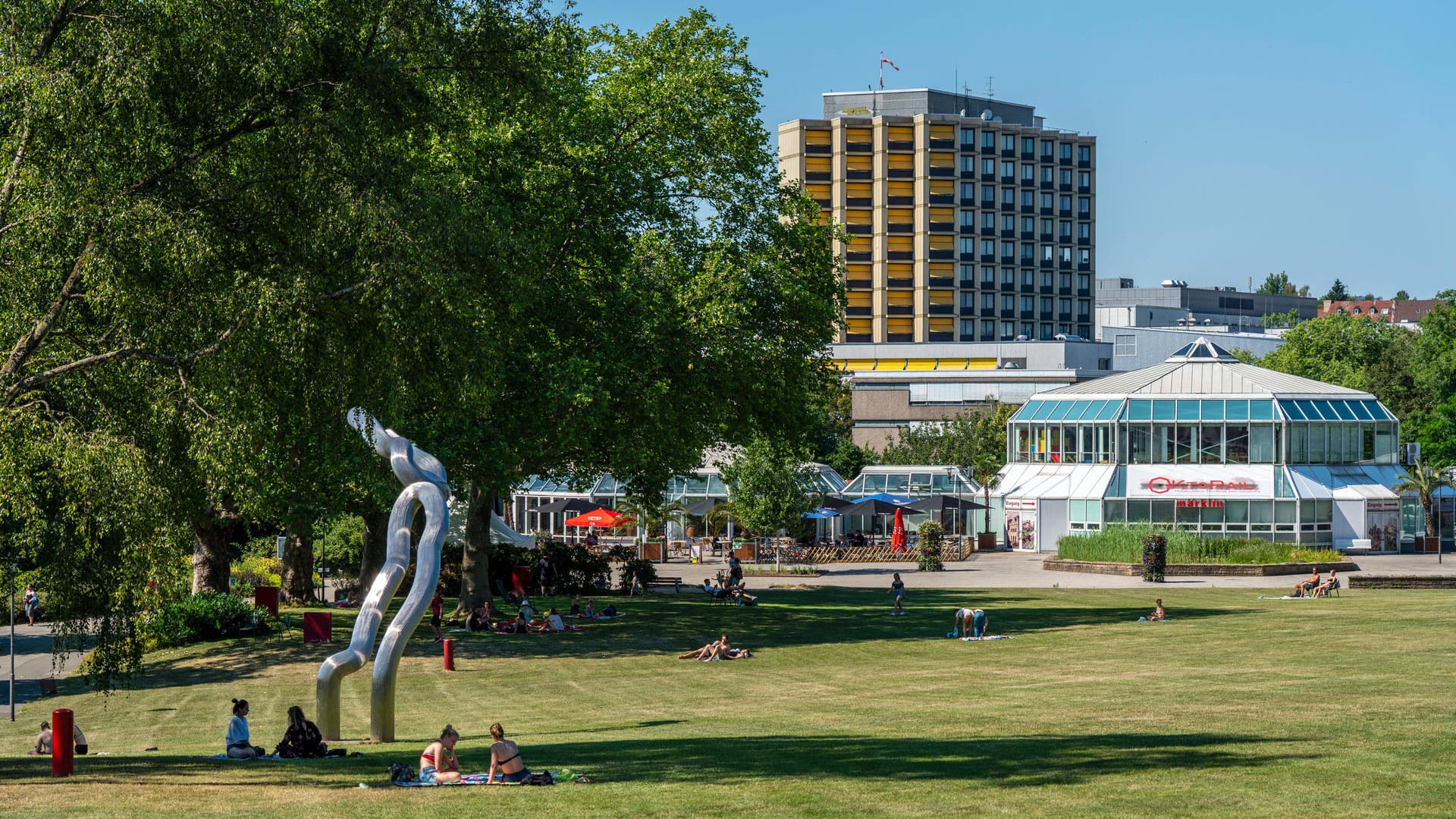 Besucher sitzen auf der Kranichwiese im Grugapark: Dort steht die Skulptur "Orion" von Brigitte Matschinsky-Denninghoff und Martin Maschinsky (1987).