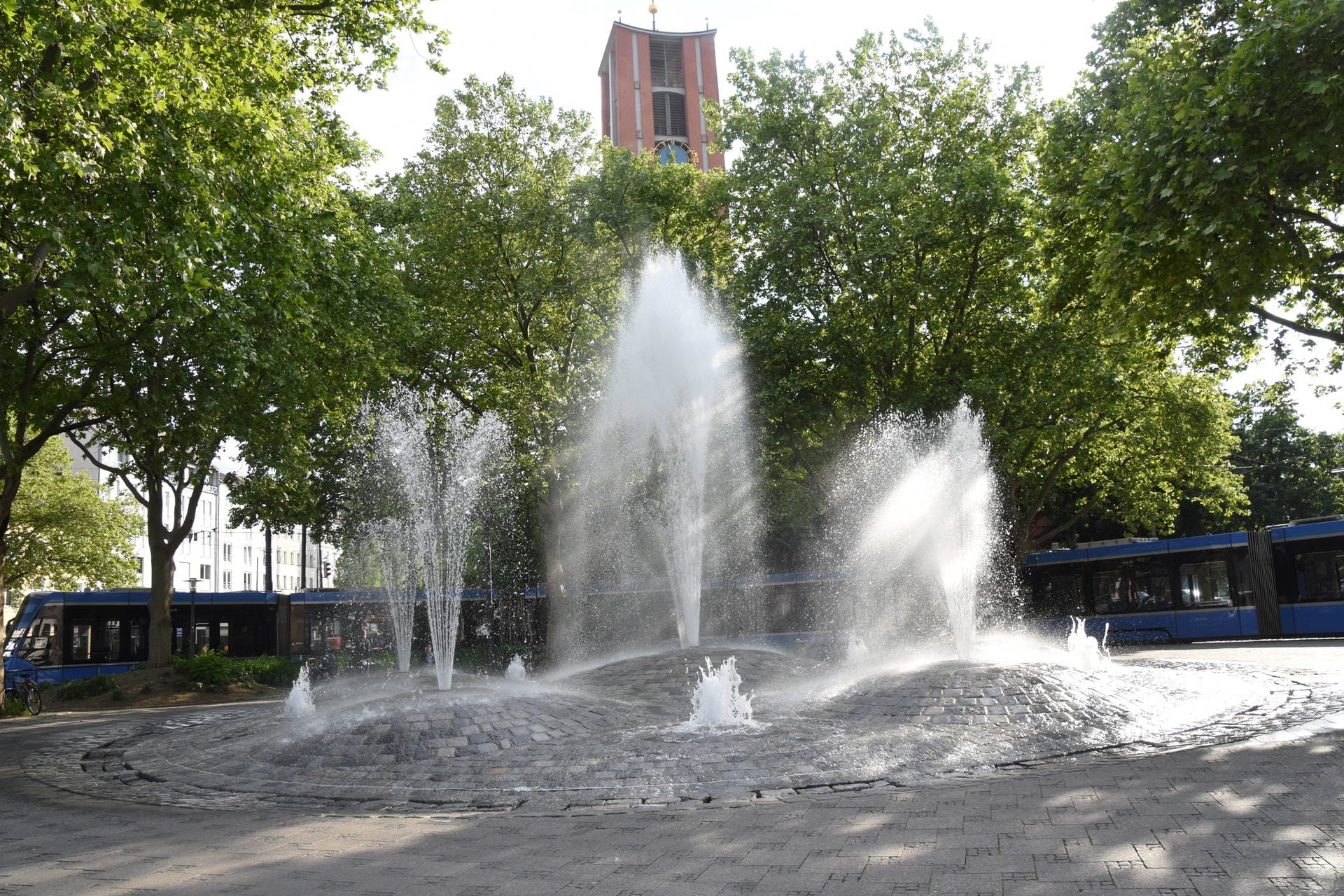Sprudelnder Brunnen am Torplatz in München: Bei sommerlichen Temperaturen toben hier viele Kinder und kühlen sich ab.