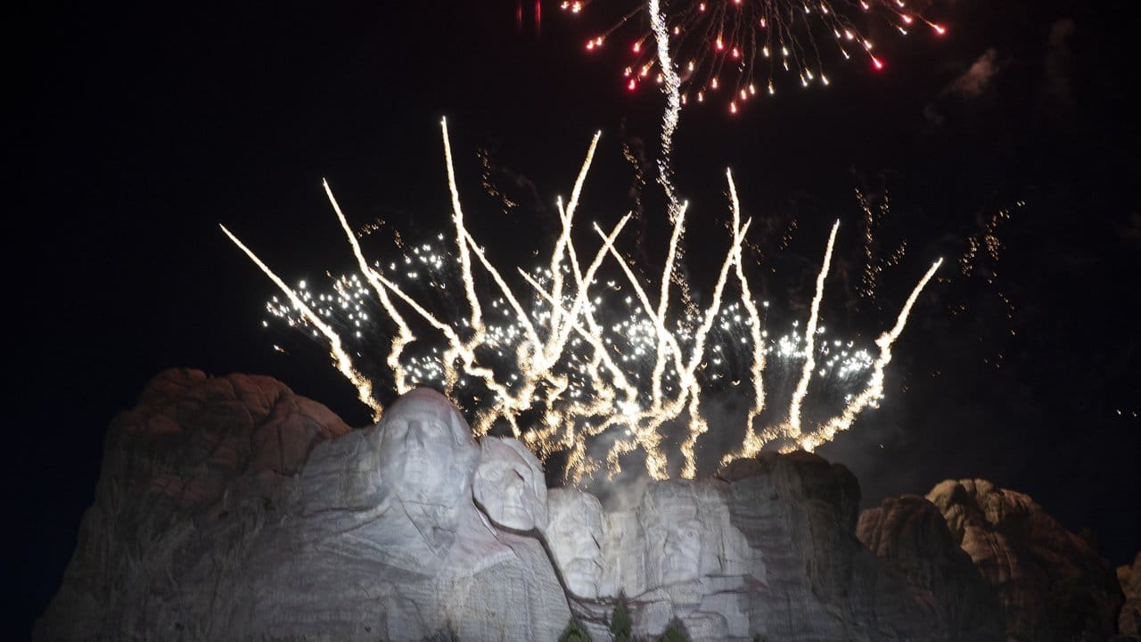 Ein Feuerwerk erhellt den Himmel am Denkmal Mount Rushmore.