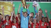 Bayern-Keeper Manuel Neuer reckt den Pott...
