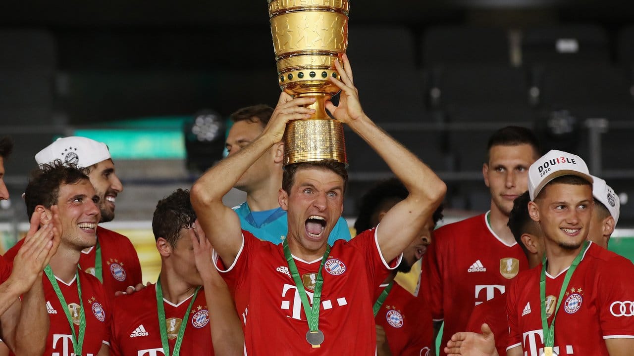 Münchens Thomas Müller hält die Trophäe nach dem Spiel hoch. Münchens Thomas Müller hält die Trophäe nach dem Spiel hoch.
