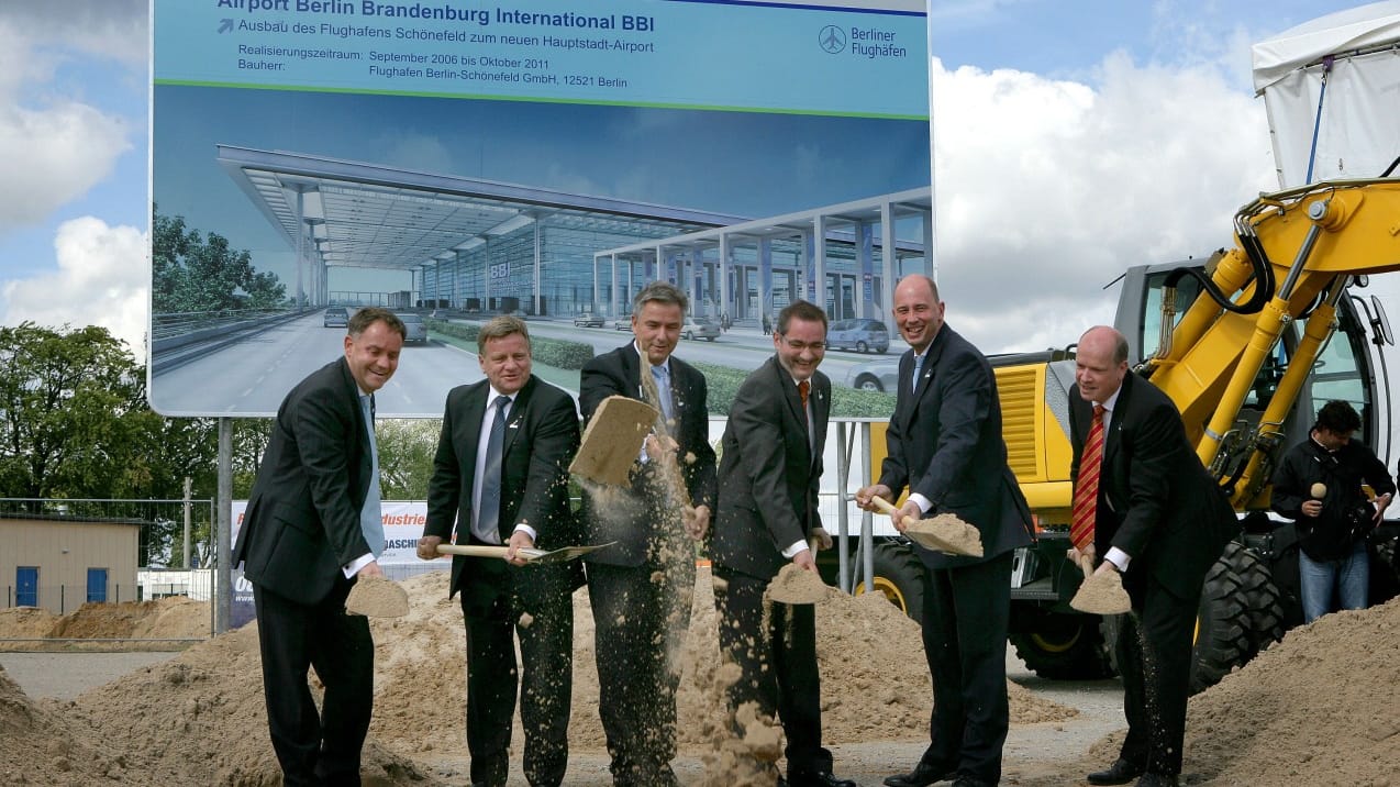 September 2006: Realisierungszeitraum bis Oktober 2011 steht auf dem Bauschild, als mit dem Spatenstich die Arbeiten beginnen. Damals war Hartmut Mehdorn Bahnchef, Berlins Regierender Bürgermeister ist Klaus Wowereit (SPD), in Brandenburg ist Matthias Platzeck (SPD) Ministerpräsident und das Bundesverkehrsministerium leitet Wolfgang Tiefensee (SPD).