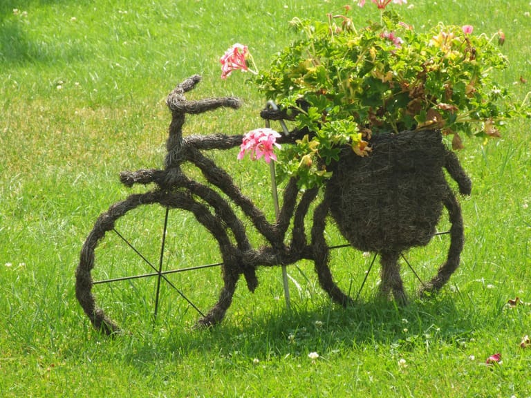 Heufahrrad mit Blumenkorb: Freilich ist es etwas mühsam, das Fahrradgestell mit Heu und Drähten zu verkleiden. Dafür erhalten Sie aber ein ganz besonderes Deko-Highlight.