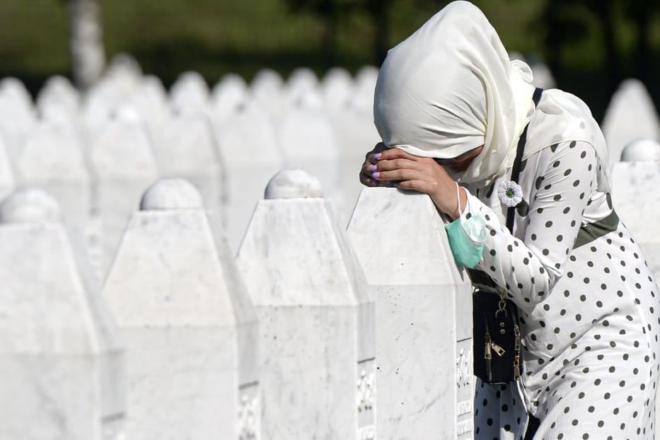 Eine Frau trauert auf dem Friedhof der Gedenkstätte Potocari in der Nähe von Srebrenica an einem Grab.
