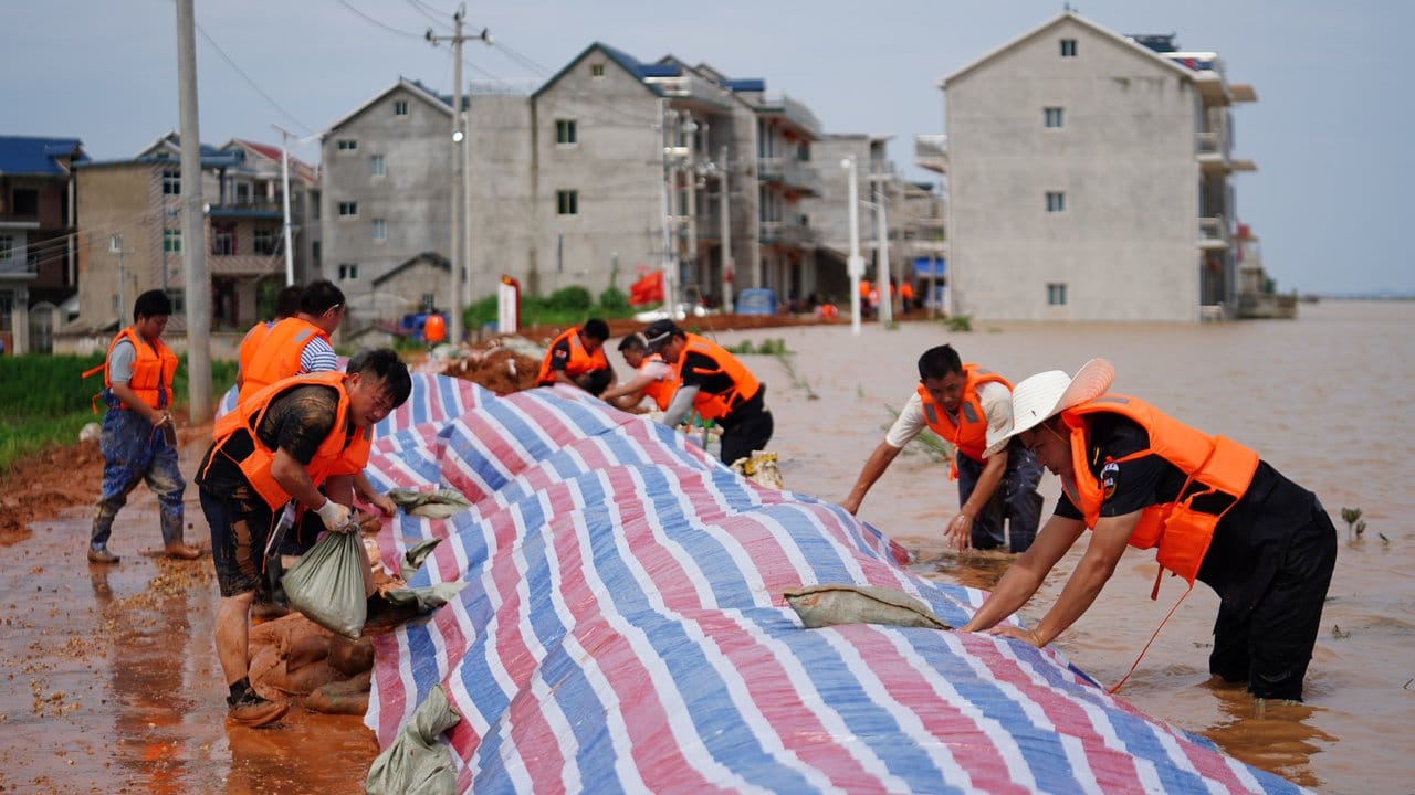 Rettungshelfer errichten einen provisorischen Deich gegen Überschwemmungen in einem Gebiet im Kreis Poyang in der ostchinesischen Provinz Jiangxi.