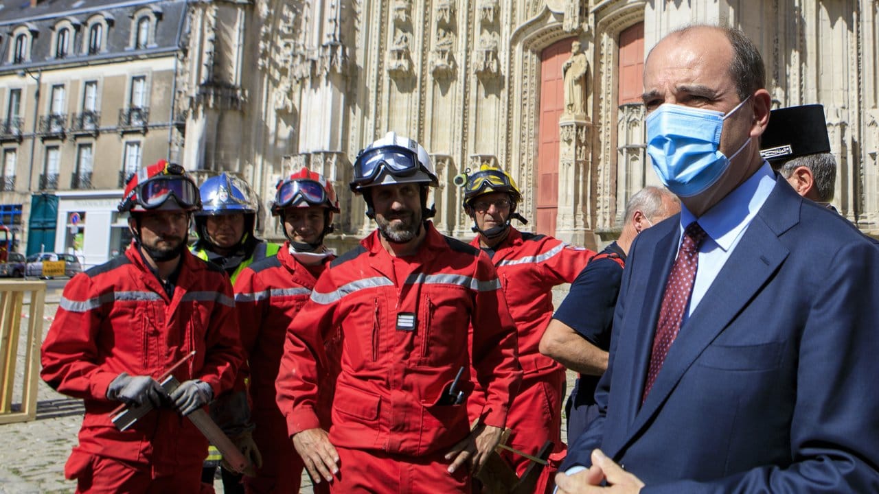 Der Premierminister von Frankreich Jean Castex trägt einen Mundschutz, während er sich mit Mitgliedern der Feuerwehr vor der Kathedrale Saint-Pierre-et-Saint-Paul trifft.