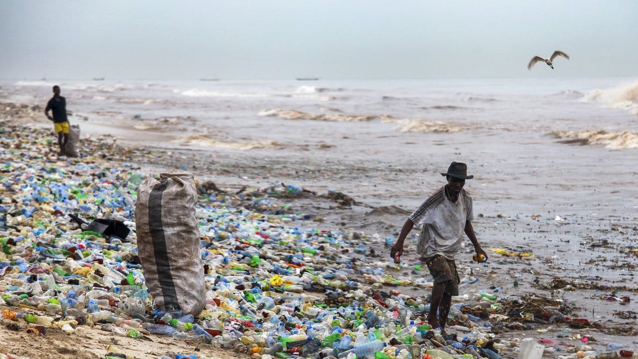 Ein Mann sammelt verwertbares Material am verschmutzten Korle Gono Strand in Ghana.