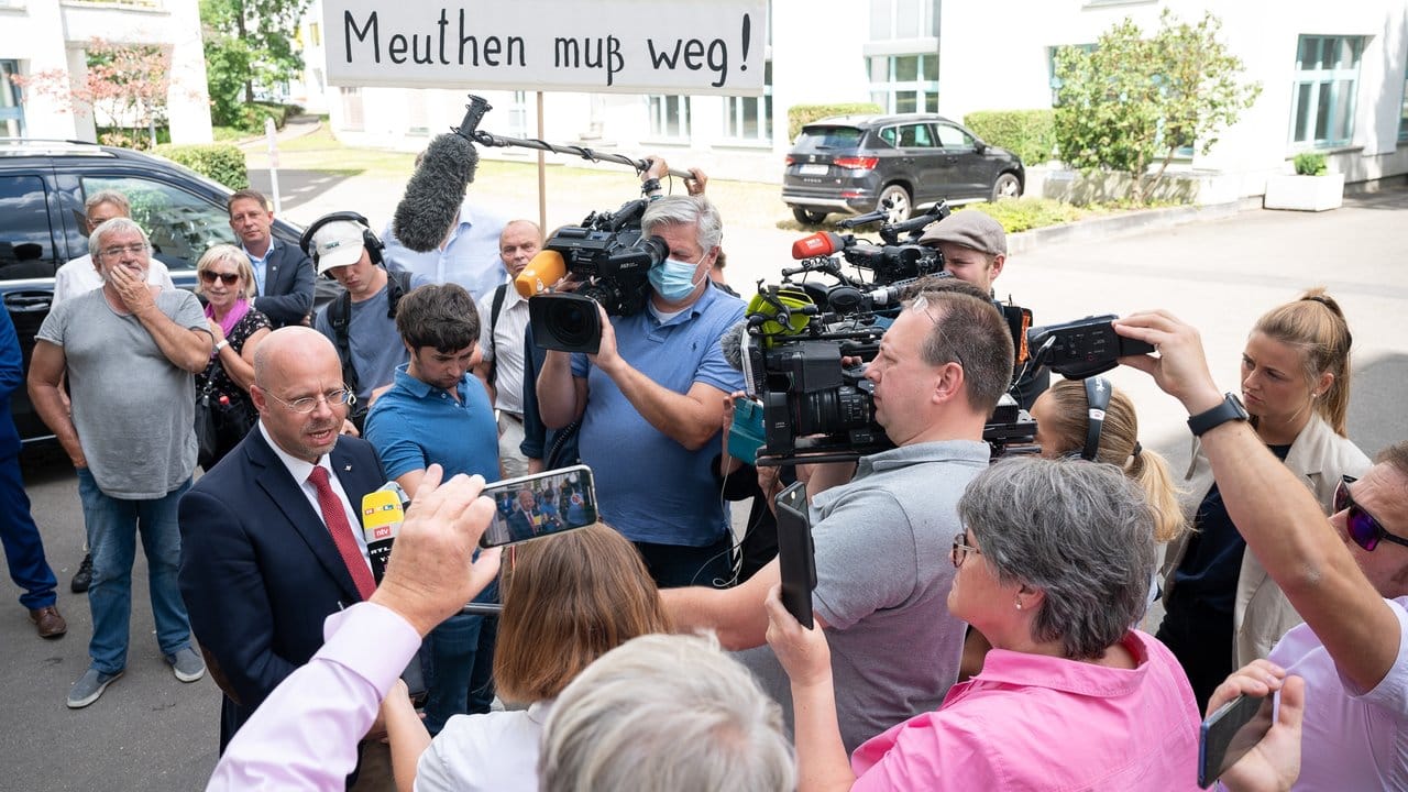 Andreas Kalbitz im Gespräch mit Journalisten - im Hintergrund haben sich Unterstützer versammelt.