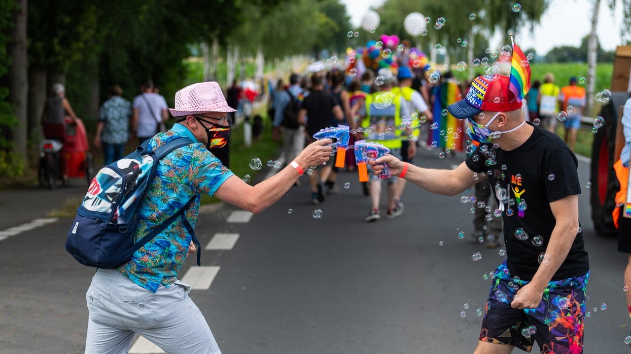 Zwei Teilnehmer der Parade zum Christopher Street Day (CSD) beschießen sich mit Seifenblasen.