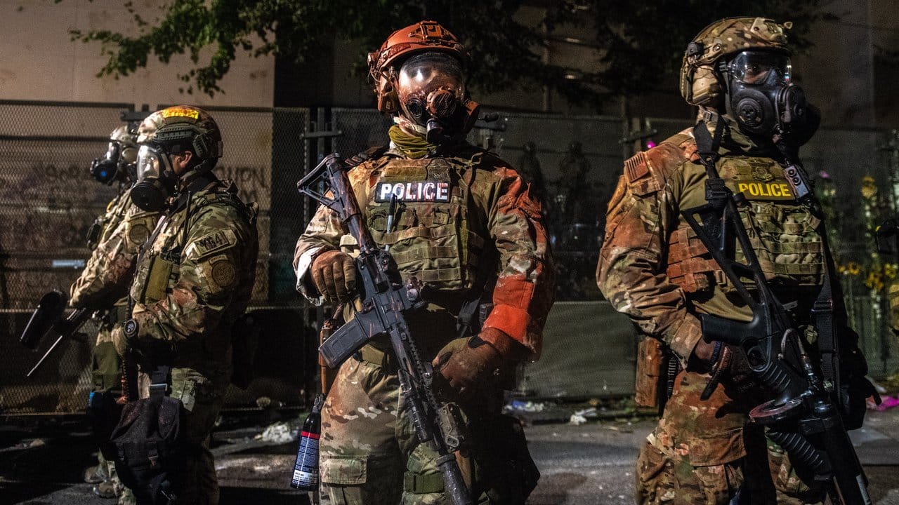 US-Bundespolizisten stehen mit der Hand an der Waffe am Rande von Protesten in Portland. US-Bundespolizisten stehen mit der Hand an der Waffe am Rande von Protesten in Portland.