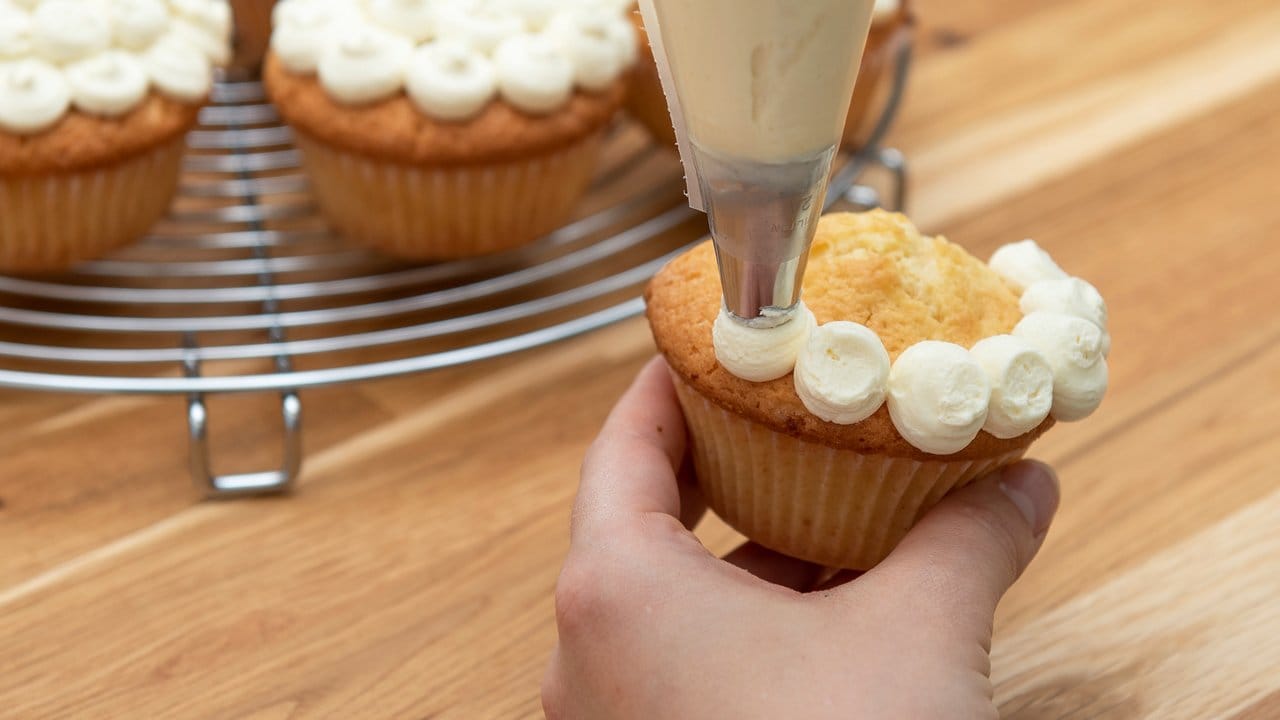 Bei einem Tupfenmuster spritzt man kleine Kügelchen nebeneinander auf den Cupcake. Bei einem Tupfenmuster spritzt man kleine Kügelchen nebeneinander auf den Cupcake.
