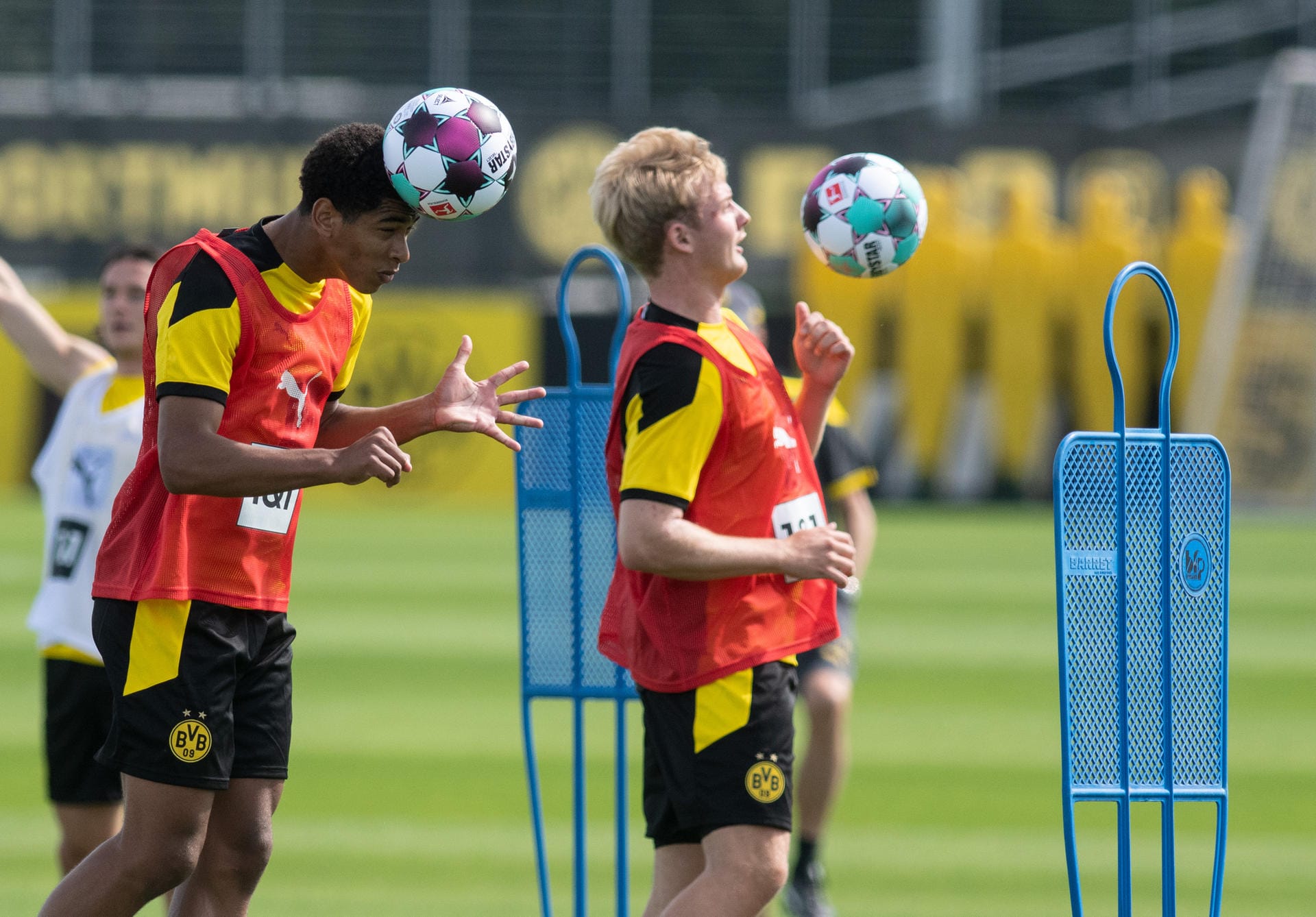 Jude Bellingham (l) und Julian Brandt: Beide nehmen einen Fußball beim Training an.