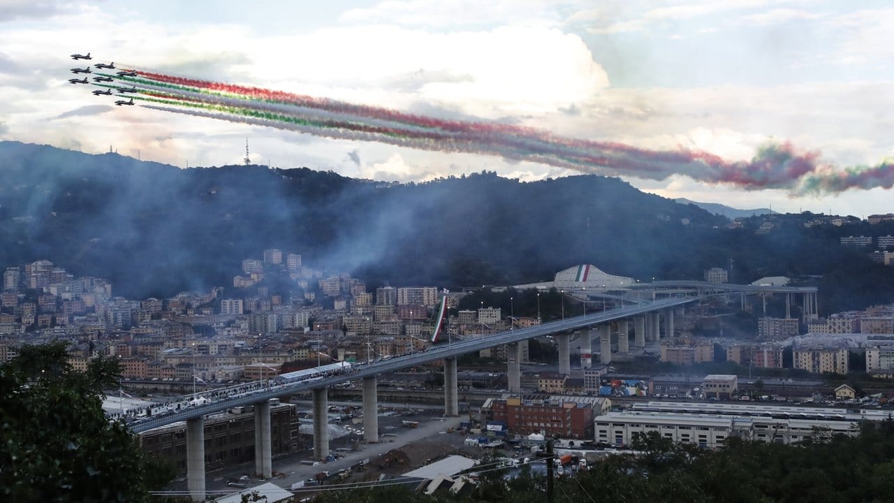 Die Kunstflugstaffel Frecce Tricolori fliegt bei der Einweihung in Genua über die neue Brücke hinweg. Die Kunstflugstaffel Frecce Tricolori fliegt bei der Einweihung in Genua über die neue Brücke hinweg.