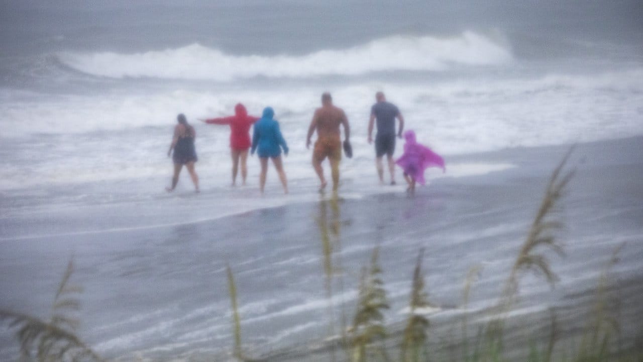 Bei stürmischem Wetter stehen Menschen am Strand der bei Urlaubern beliebten Stadt Myrtle Beach in North Carolina.