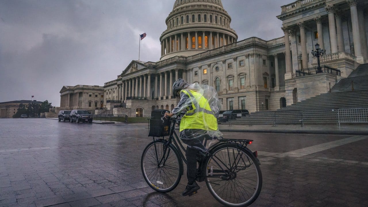 Eine Fahrradfahrerin kämpft auf dem Capitol Hill in Washington gegen Wind und starken Regen.