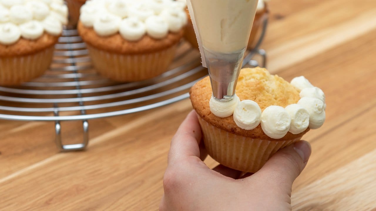 Bei einem Tupfenmuster spritzt man kleine Kügelchen nebeneinander auf den Cupcake.