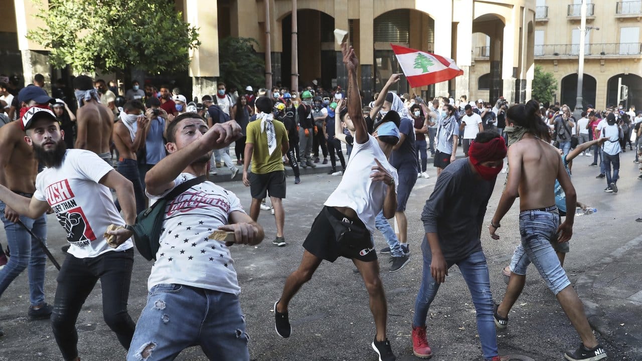 Demonstranten werfen in Beirut Steine auf libanesische Bereitschaftspolizisten.
