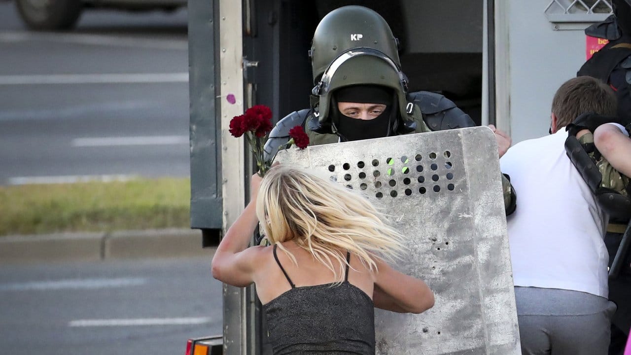 Eine Frau im Clinch mit einem Polizisten, nachdem viele Demonstranten festgenommen worden sind.