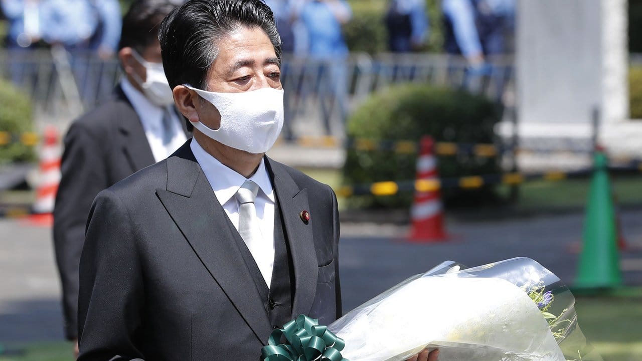 Shinzo Abe, Ministerpräsident von Japan, trägt einen Blumenstrauß, den er auf dem Chidorigafuchi Nationalfriedhof für die nicht identifizierten Überreste der Kriegstoten niederlegt.