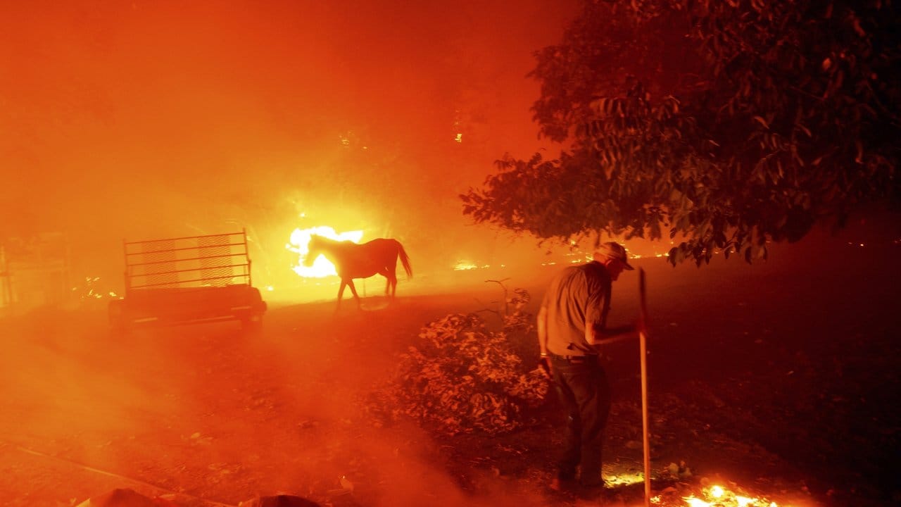 Der 84-Jährige Bill Nichols versucht in Vacaville, sein Haus vor den Flammen zu retten.