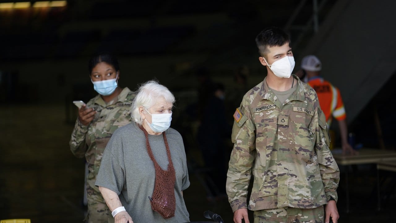 Eine ältere Frau wird in Lake Charles, Louisiana, während der Evakuierung von einem Soldaten begleitet.