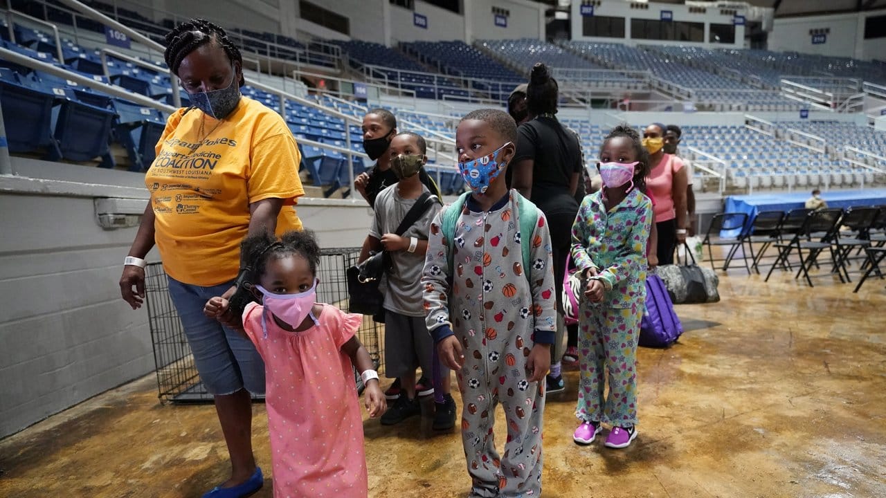 Frauen und Kinder warten in einer Sporthalle in Lake Charles im US-Bundesstaat Louisiana darauf, in eine Notunterkunft gebracht zu werden.