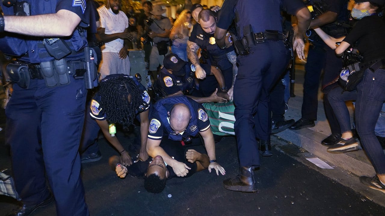 Polizisten drücken einen Demonstranten am Black Lives Matter Plaza in Washington auf die Straße.