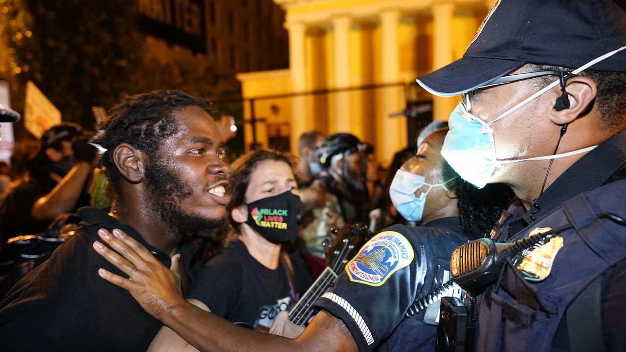 Ein Demonstranten spricht mit einer Polizistin während eines Protests gegen US-Präsident Trump auf dem "Black Lives Matter"-Plaza.