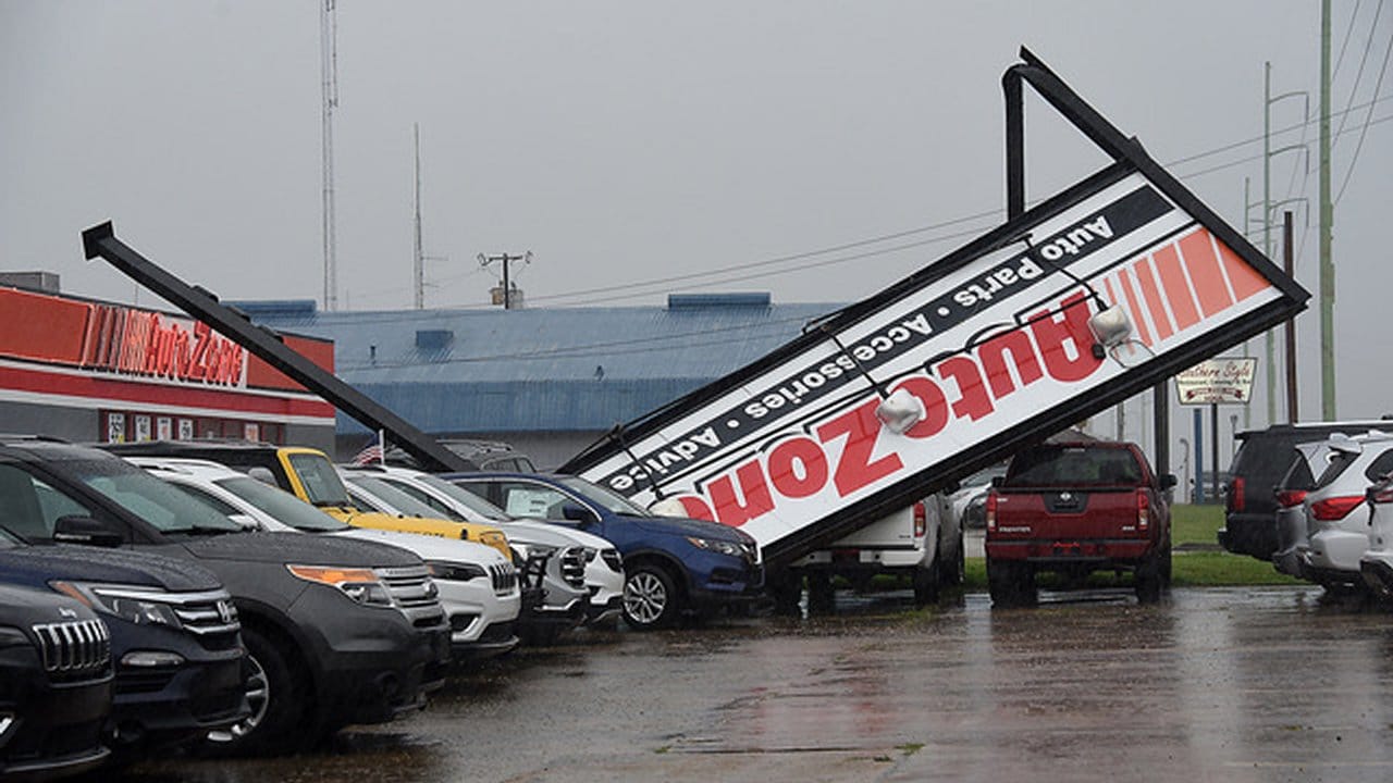 Ein umgestürztes Schild eines Geschäftes liegt auf Autos am Devereux Drive in Natchez, nachdem Hurrikan "Laura" durchgezogen ist.