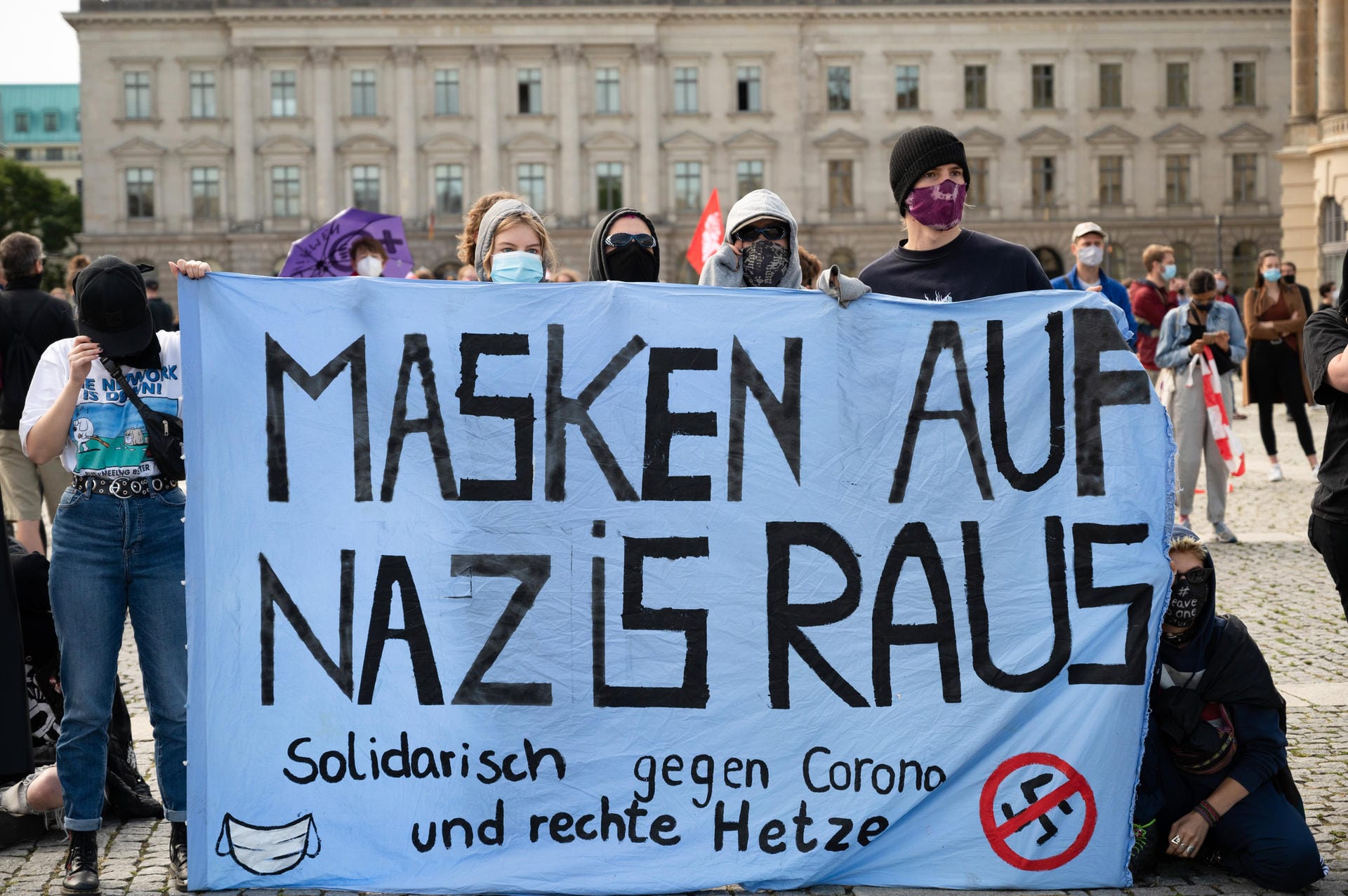 Die Gegendemonstranten halten Banner hoch mit Sprüchen wie "Masken auf Nazis raus".