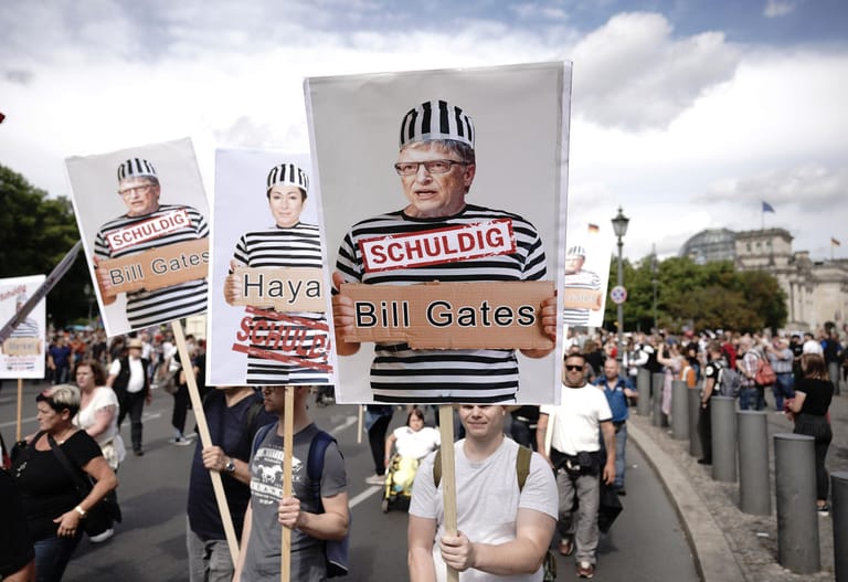 Teilnehmer halten Schilder mit Fotos von Politikern, Journalisten und Wissenschaftlern und dem Wort "Schuldig" in die Höhe.
