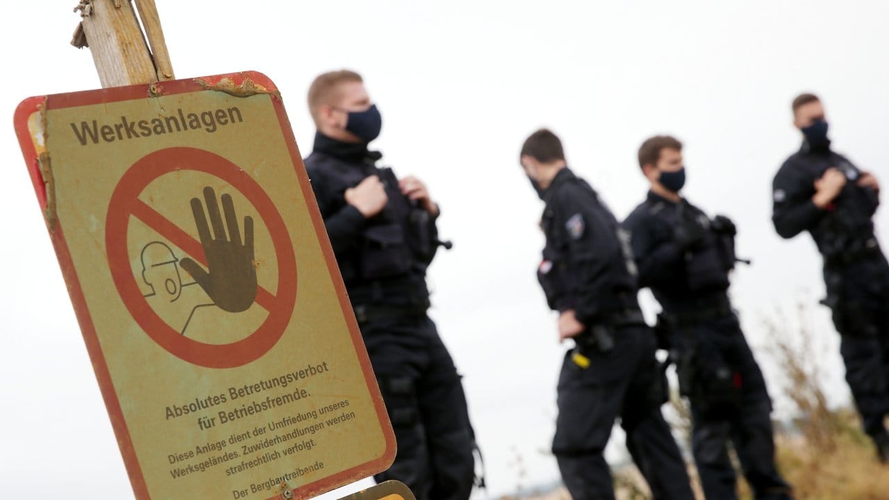 Polizisten stehen im Tagebau Garzweiler an der Abbruchkante.