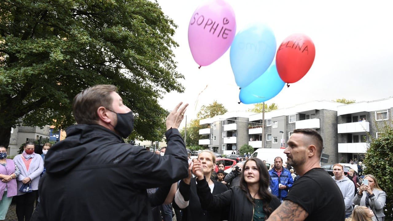 Zusammen mit Oberbürgermeister Tim Kurzbach (l) lassen Nachbarn als Ausdruck ihrer Trauer fünf Luftballons mit den Namen der fünf getöteten Kinder vor dem Haus der Familie steigen.