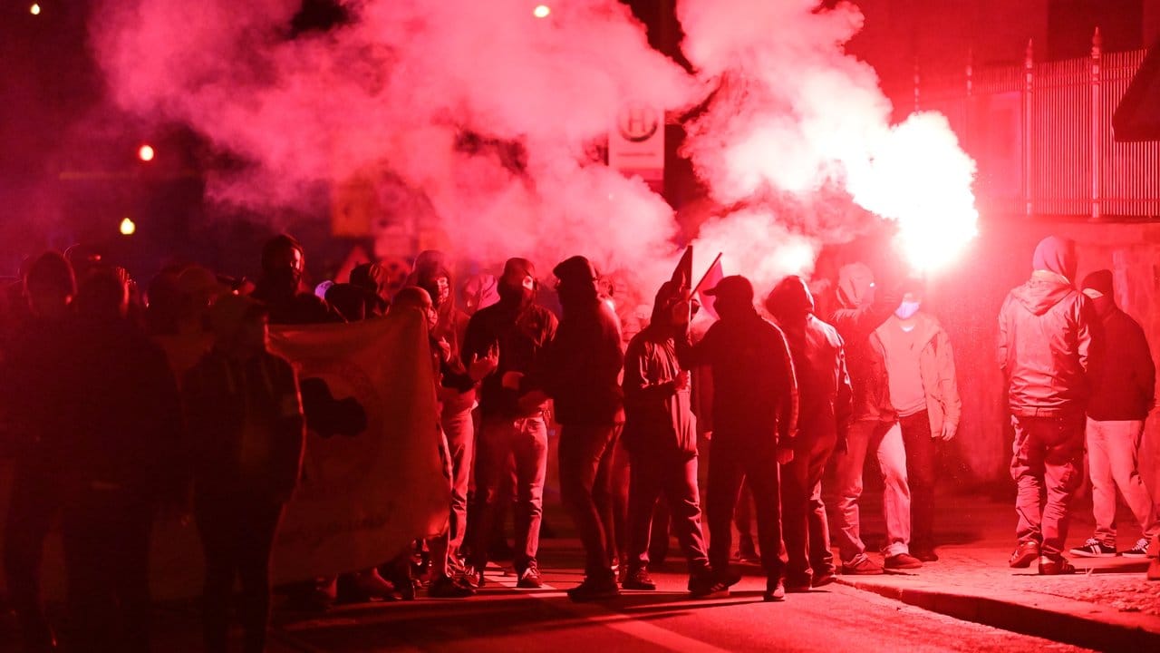 Teilnehmer der Demonstration unter dem Motto "Kämpfe verbinden - Für eine solidarische Nachbar*innenschaft" ziehen mit roten Pyro-Fackeln durch den Leipziger Stadtteil Connewitz.