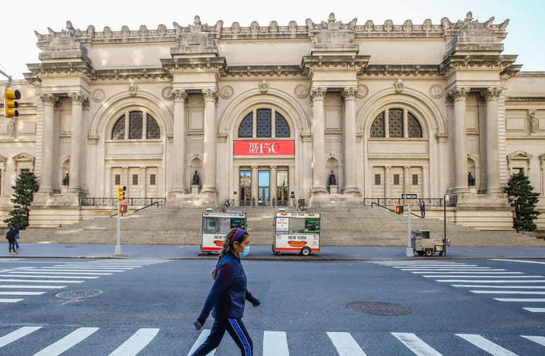 Nur wenige sind unterwegs: Eine Frau mit Mundschutz geht vor dem Metropolitan Museum of Art über die Straße.