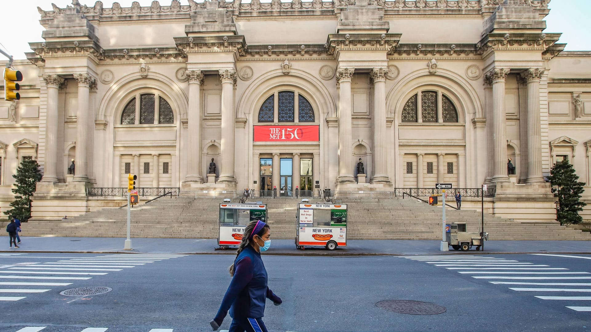 Nur wenige sind unterwegs: Eine Frau mit Mundschutz geht vor dem Metropolitan Museum of Art über die Straße.