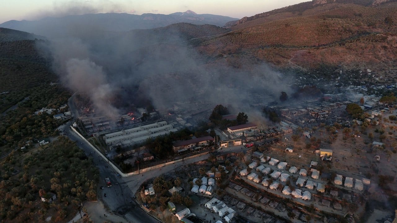 Rauch steigt aus Container-Häuser und Zelten im Flüchtlingslager Moria auf.
