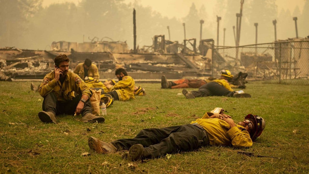 Eine Feuerwehrmannschaft macht eine Pause neben einer Schule in Berry Creek in Nordkalifornien, die durch ein Feuer zerstört wurde.